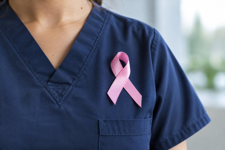 A pink breast cancer awareness ribbon pinned to a navy medical uniform